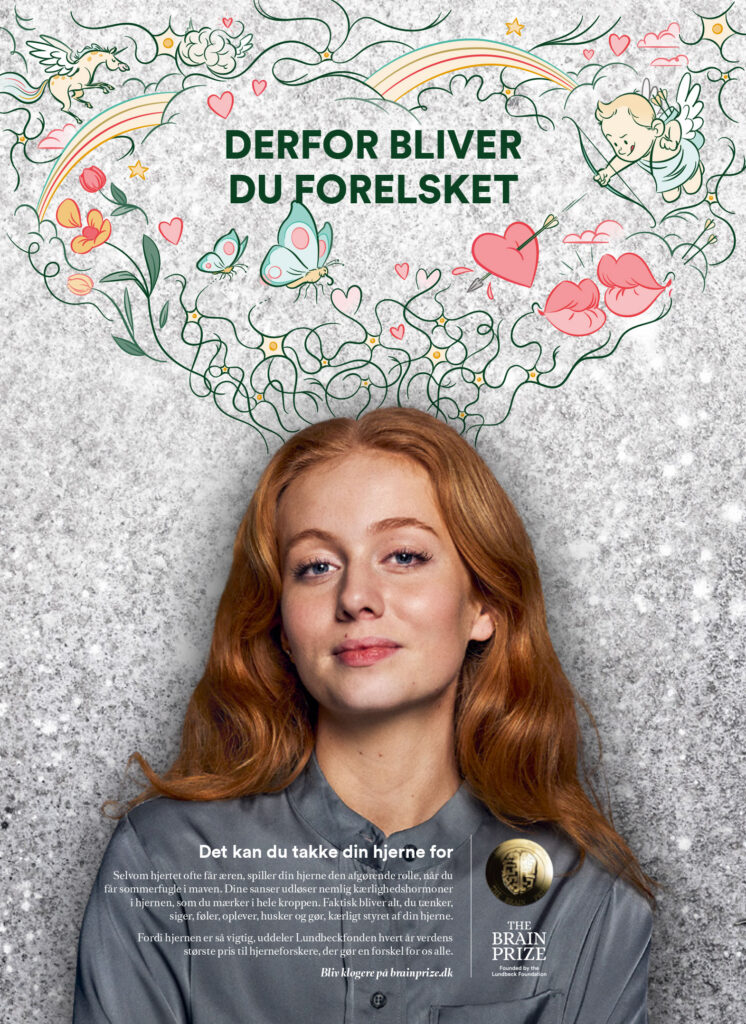 A campaign poster featuring a young woman with long red hair looking forward with a slight smile. Above her head, a cloud of stylized green line art illustrates romantic themes: a cupid with a bow, a flying Pegasus, hearts, butterflies, and lips. The bold green headline reads 'DERFOR BLIVER DU FORELSKET' (That's why you fall in love), with text below detailing how love hormones are triggered by the senses.
