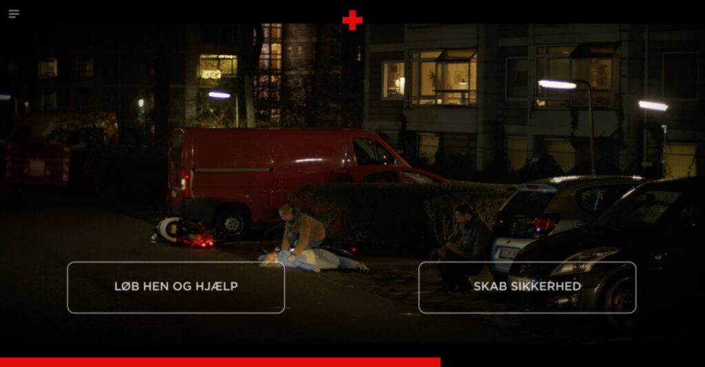 A widescreen still from an interactive video showing a nighttime street accident scene with a red van, a fallen scooter, and a person lying on the ground. Two large, transparent interactive option boxes appear at the bottom: 'LØB HEN OG HJÆLP' (Run over and help) on the left, and 'SKAB SIKKERHED' (Create safety) on the right.